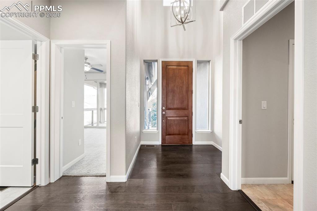 Image 9 of 49: Foyer entrance featuring wood finished floors, hanging lights, a ceiling fa