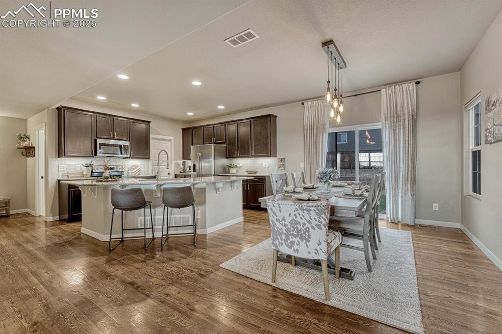 Image 10 of 50: Dining Area and Kitchen with slider to the backyard patio.