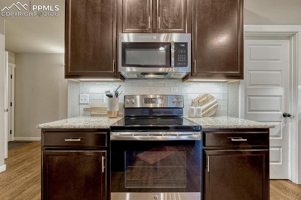 Image 16 of 50: The Kitchen boasts a smooth top range oven and built-in microwave.