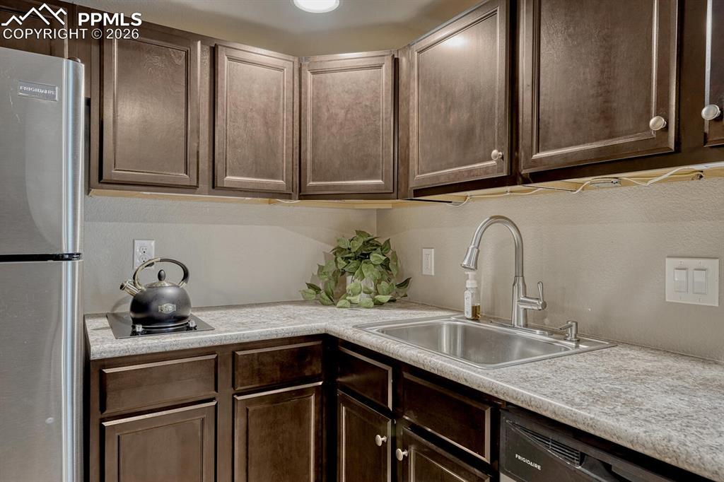 Image 39 of 50: Espresso cabinets with stainless steel sink and lots of counterspace.