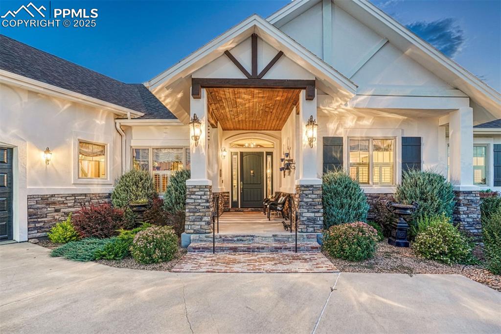 Image 11 of 45: The covered entry, welcoming and tastefully lit, sets the tone as you enter