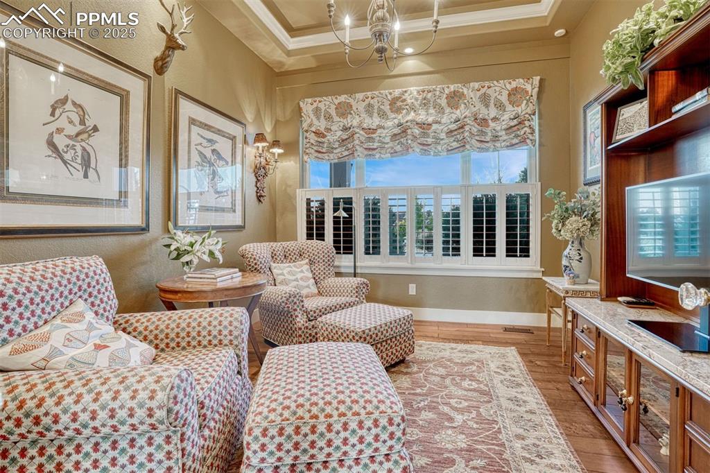 Image 19 of 45: Tucked away upstairs is a flex space with classic wood shutters, French doo