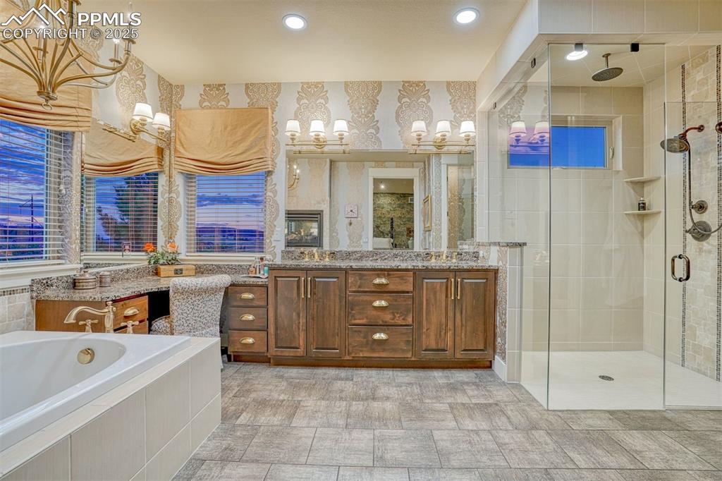 Image 21 of 45: Featuring double sinks, a built-in vanity and oversized glass-enclosed show
