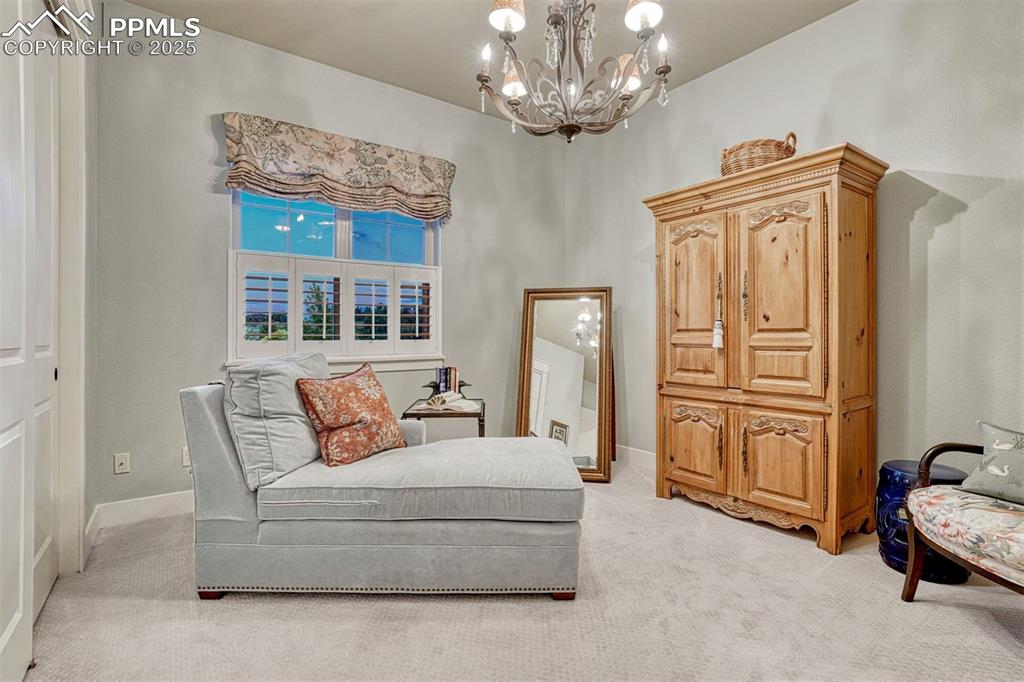 Image 25 of 45: Bedroom with classic wood shutters, plush carpet and a view to the lush yar