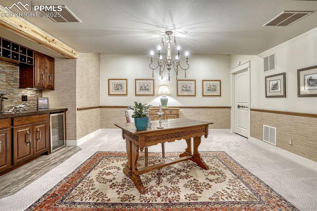 Image 31 of 45: Downstairs easily becomes the social center of the home. The wet bar with d