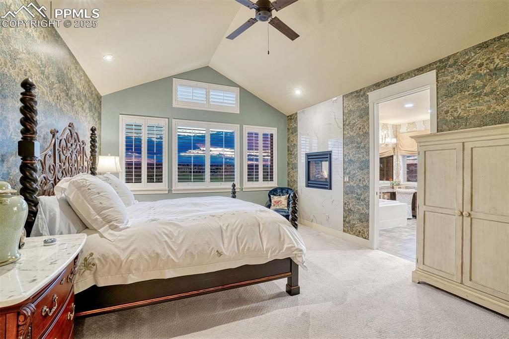 Image 5 of 45: Main level primary en-suite, elegantly appointed with 2-sided fireplace sur