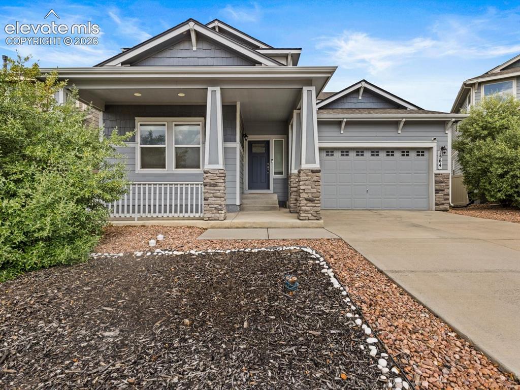 Image 1 of 45: Contemporary residence featuring a covered front porch with stone-clad colu