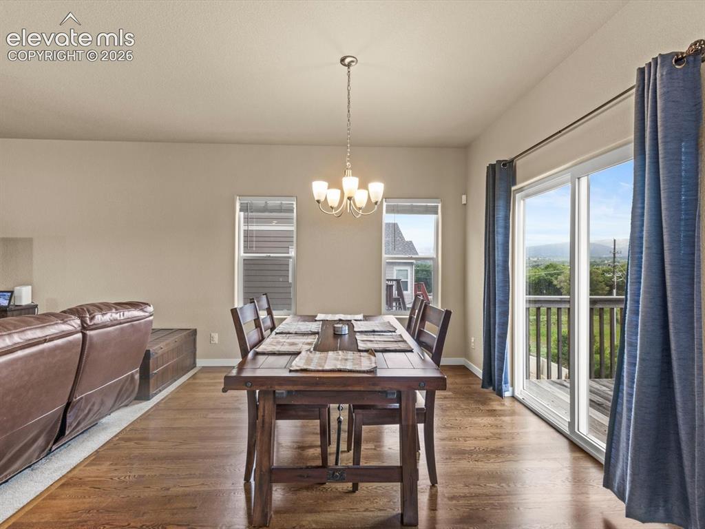 Image 12 of 45: Dining area featuring wood-finish flooring and a central chandelier
