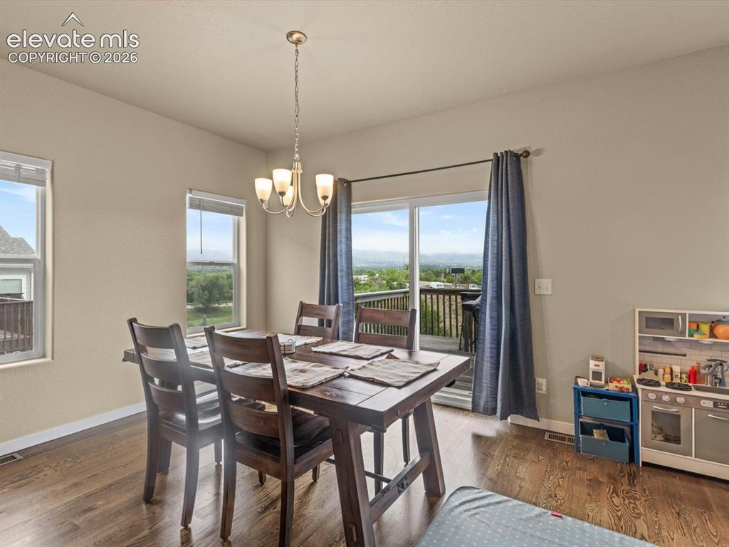 Image 13 of 45: Dining space featuring wood-finish flooring, a contemporary chandelier, and