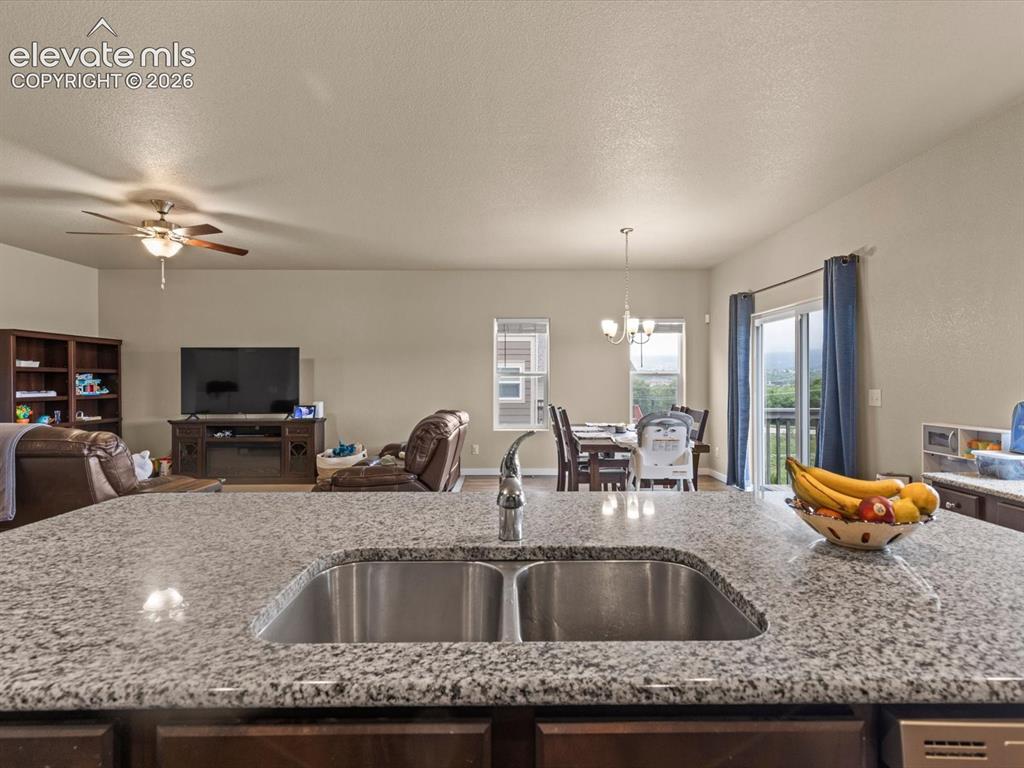 Image 20 of 45: Granite countertop island featuring a double stainless steel sink