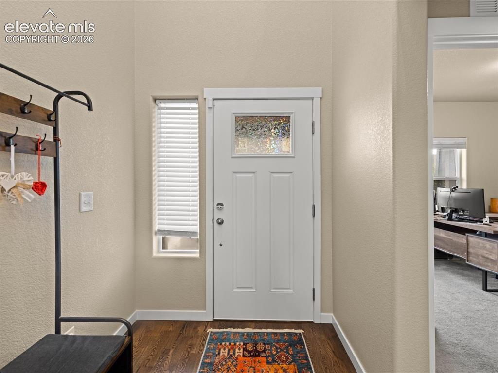 Image 5 of 45: Entryway featuring a white paneled door with decorative glass insert, rich 