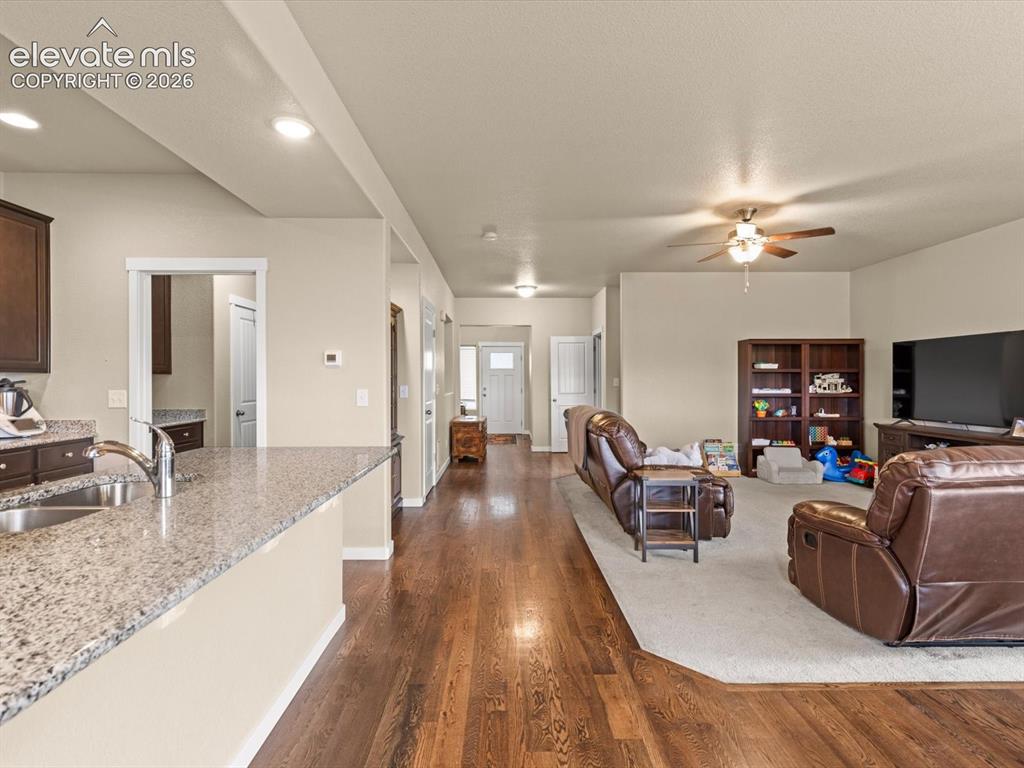 Image 6 of 45: Open-concept living space featuring wood-finish flooring extending into the