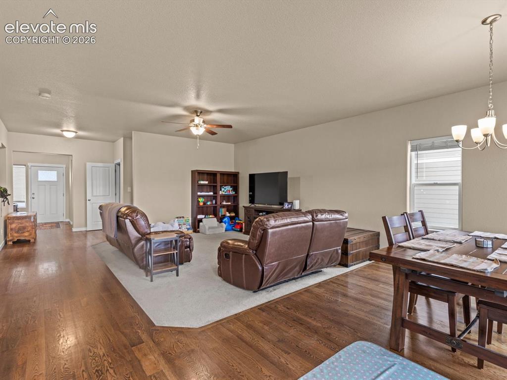 Image 7 of 45: Open-concept living area featuring rich wood-finish flooring, recessed ligh