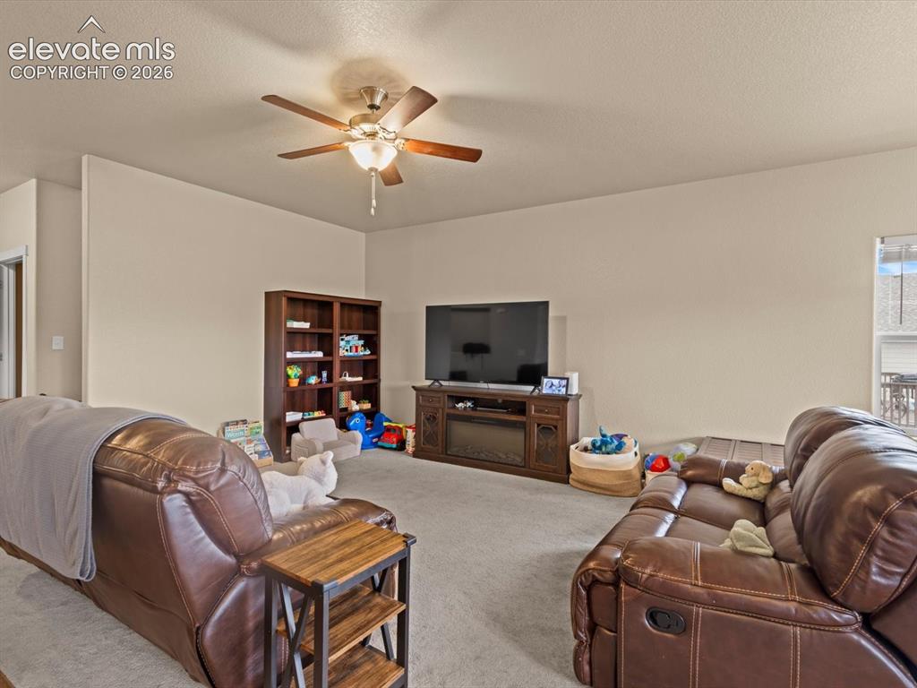 Image 9 of 45: Living space featuring a ceiling fan, light-toned wall paint, and carpeted 