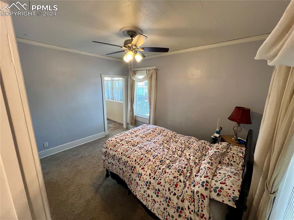 Image 12 of 18: Carpeted bedroom featuring ceiling fan and ornamental molding