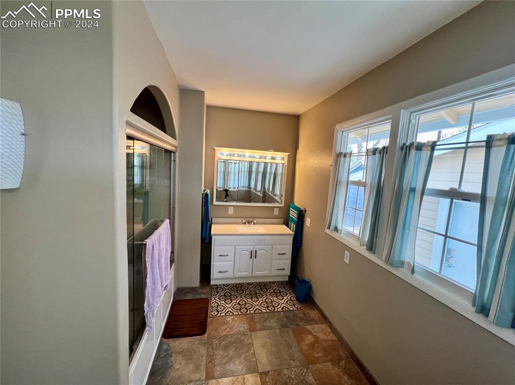 Image 14 of 18: Bathroom with tile flooring and vanity with extensive cabinet space