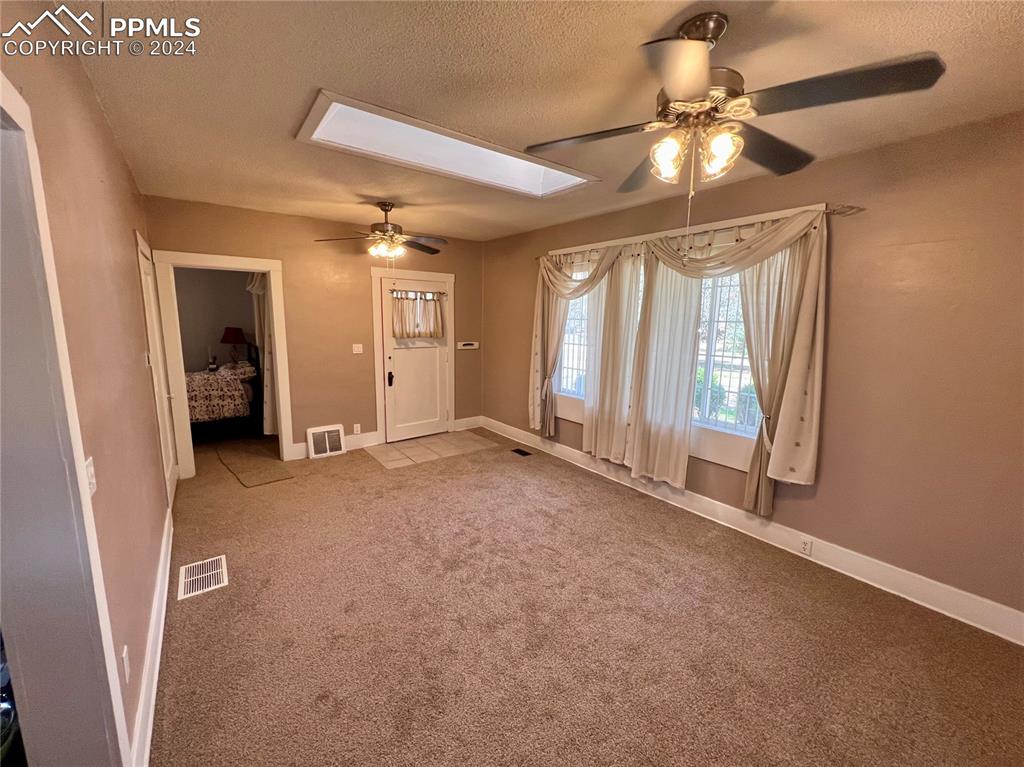 Image 8 of 18: Carpeted empty room featuring a textured ceiling and ceiling fan