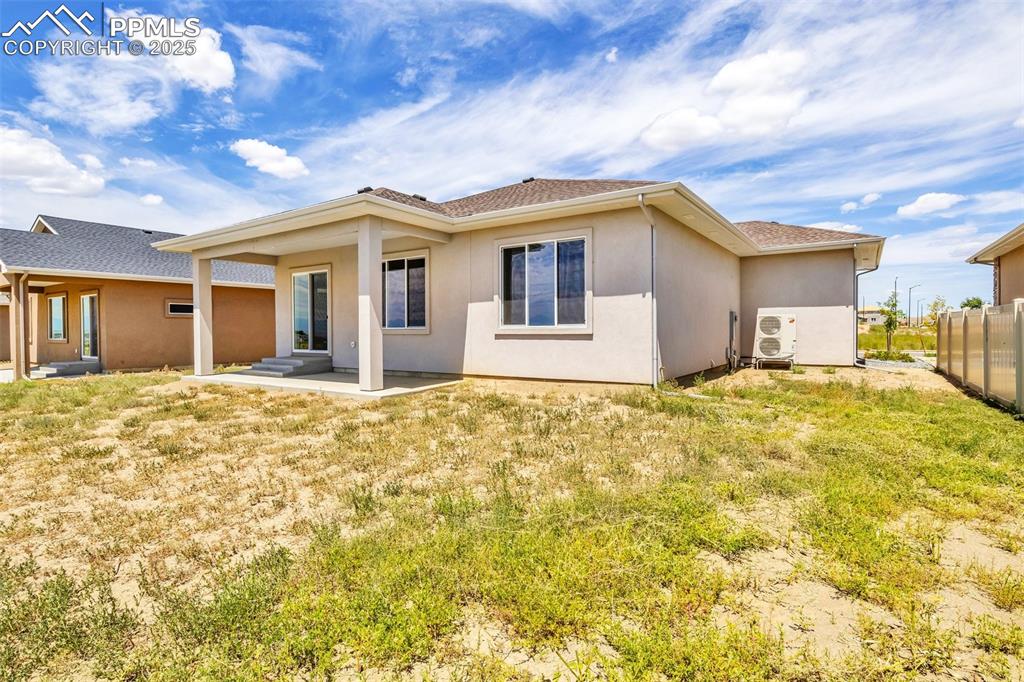 Image 14 of 50: Rear view of property featuring fence and stucco siding