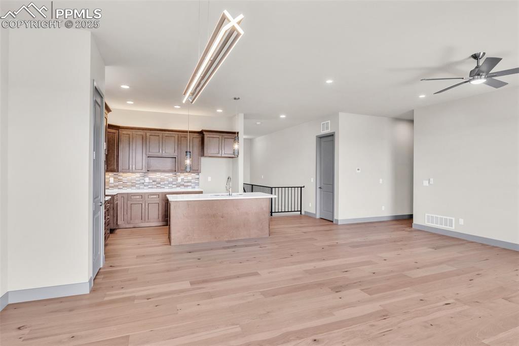 Image 17 of 50: Kitchen with open floor plan, visible vents, and a sink
