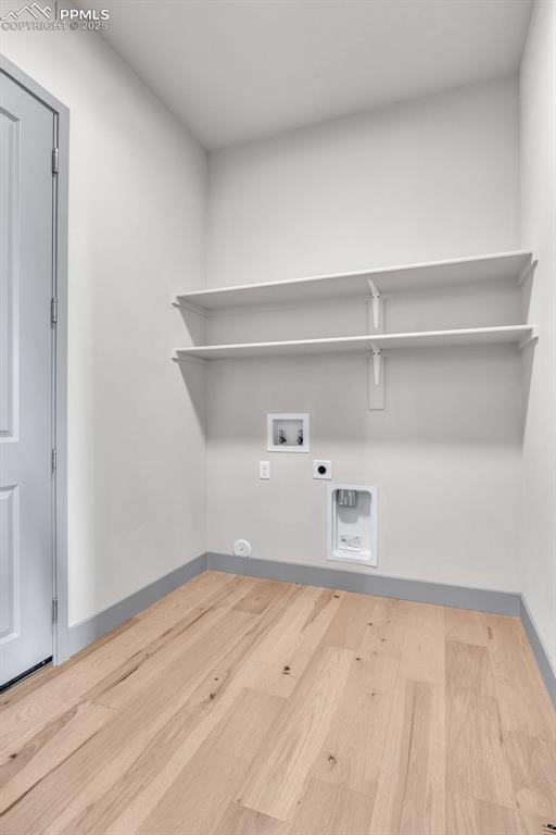 Image 32 of 50: Washroom with baseboards, washer hookup, laundry area, wood finished floors