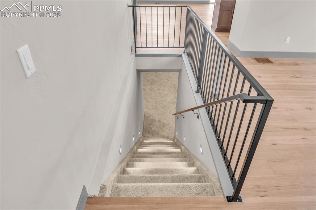 Image 34 of 50: Staircase with visible vents and wood finished floors