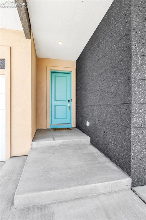 Image 37 of 50: Entrance to property with stucco siding