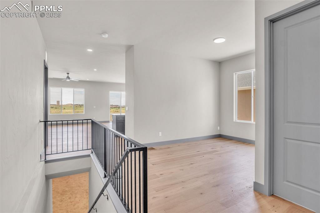 Image 42 of 50: Hallway with an upstairs landing, recessed lighting, light wood-type floori