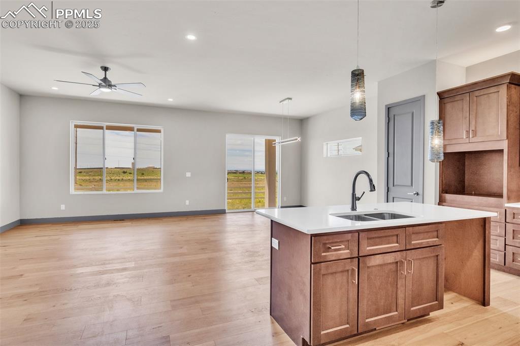 Image 46 of 50: Kitchen with open floor plan, light wood-style flooring, a center island wi