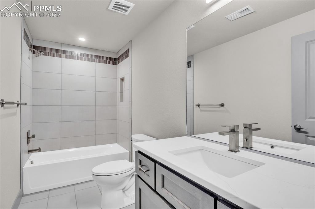 Image 8 of 50: Bathroom with tile patterned flooring, visible vents, toilet, and vanity