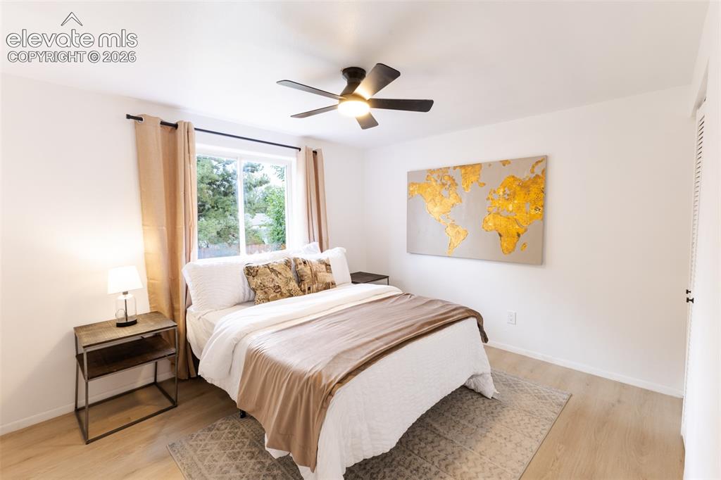 Image 14 of 32: Wood-finish flooring, white walls, black ceiling fan with integrated lighti