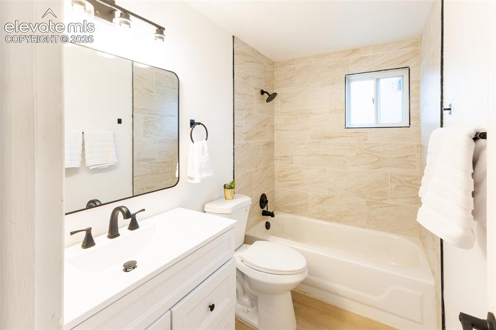 Image 18 of 32: White vanity with a white countertop and matte black fixtures