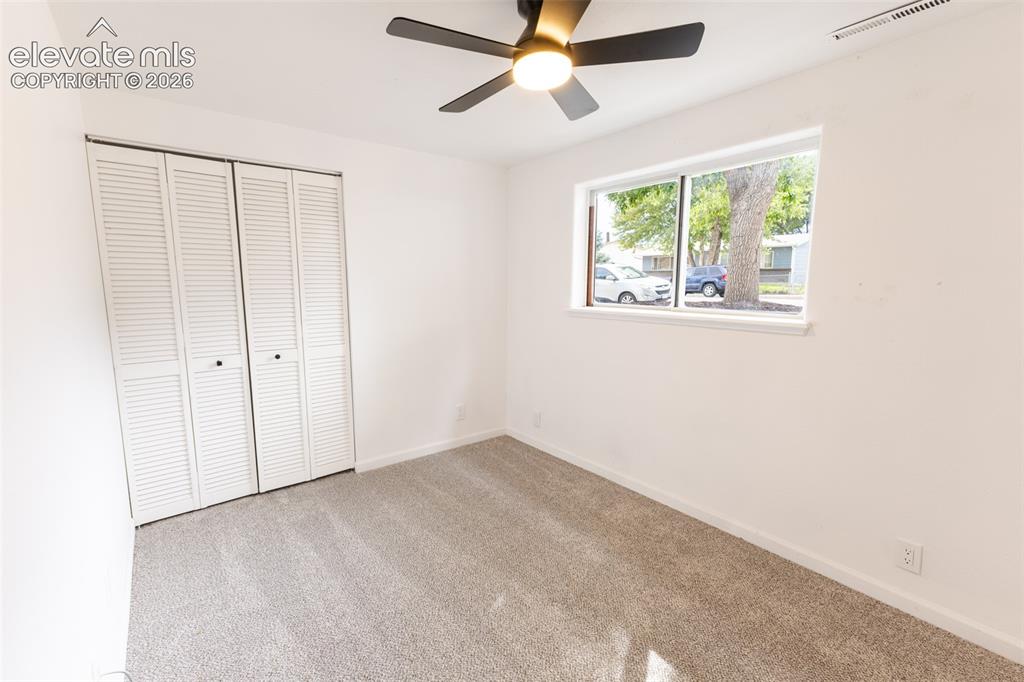 Image 22 of 32: Neutral tone wall paint, light-toned carpet flooring, white louvered bifold