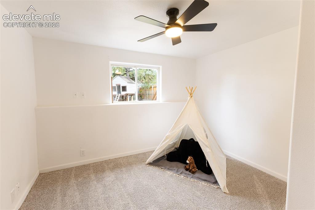 Image 24 of 32: Recessed window with exterior views, overhead ceiling fan with integrated l