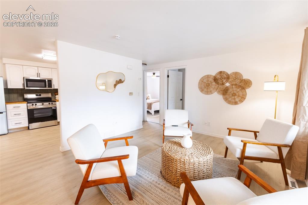 Image 3 of 32: Open living space featuring wood-finish flooring, white walls, and a recess