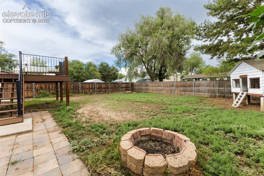 Image 30 of 32: Spacious backyard featuring a composite deck with black metal railing, a pa