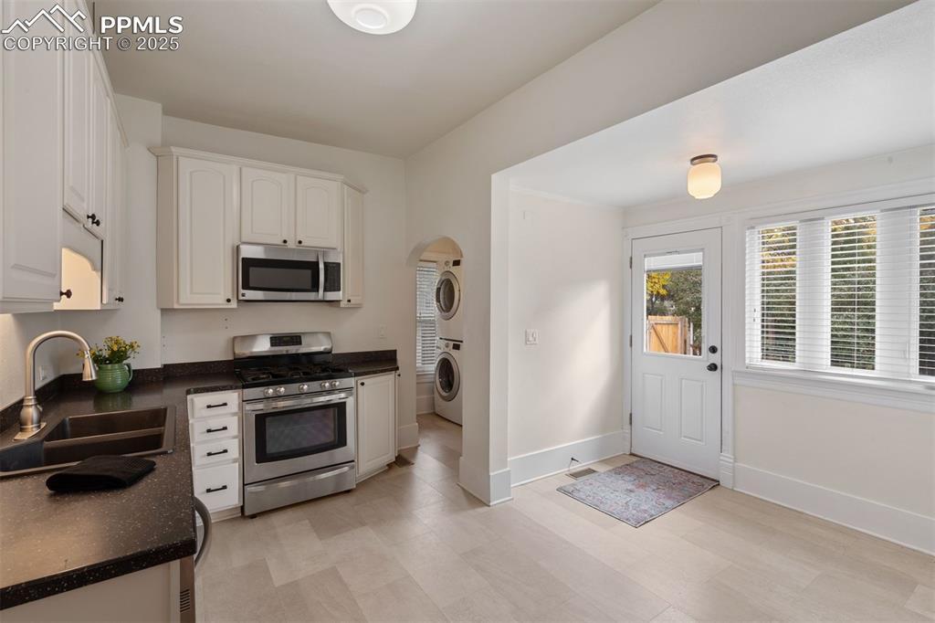 Image 6 of 32: The kitchen has access to the fully fenced back yard and detached 1 car gar