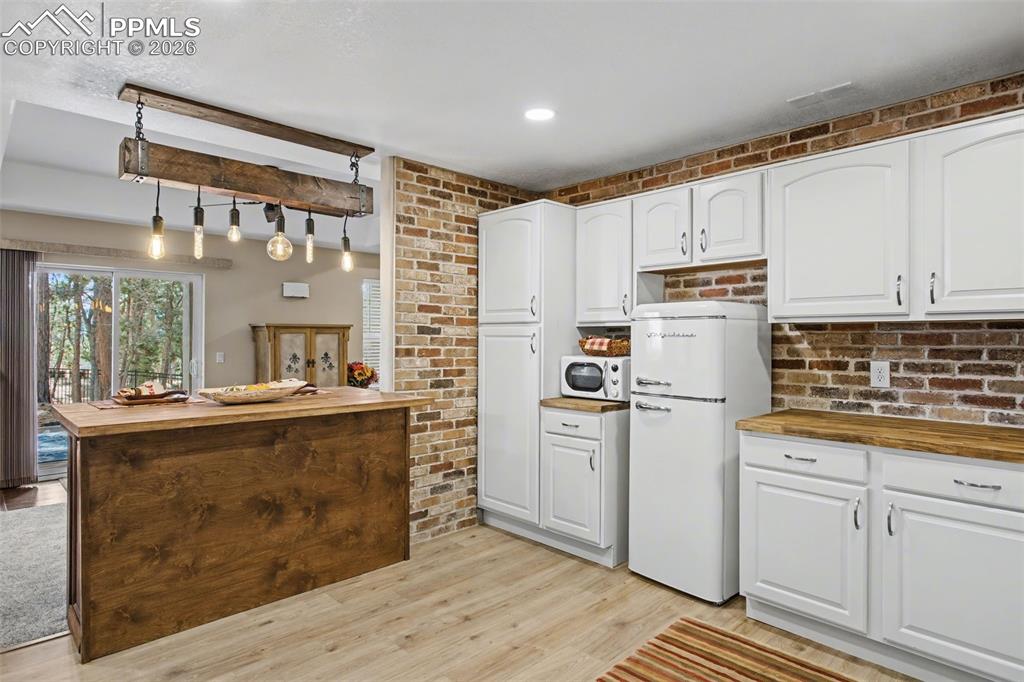 Image 30 of 50: Island lighting in new kitchenette is quirky fun.  