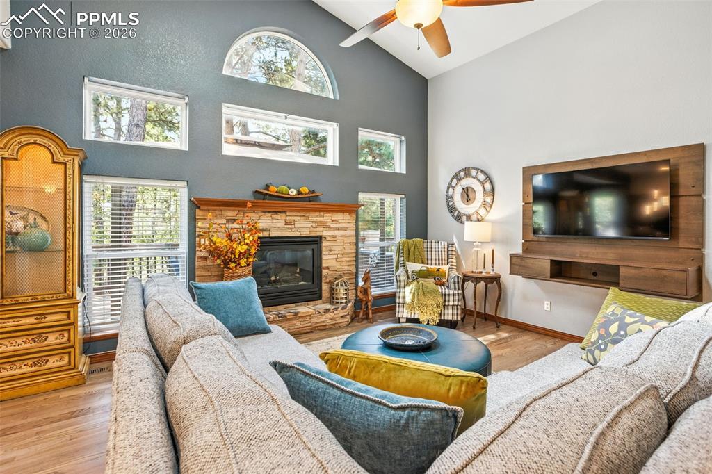 Image 8 of 50: Wall of windows surround the stacked stone gas fireplace