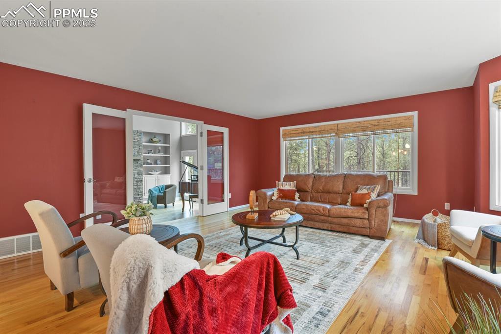 Image 13 of 50: Living room featuring wood finished floors and baseboards