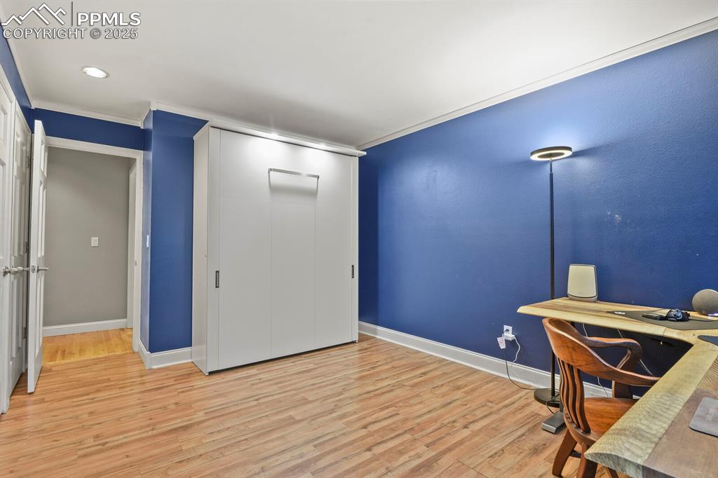 Image 17 of 50: Office area with light wood finished floors and crown molding