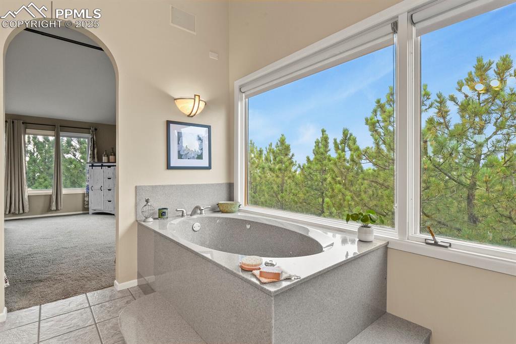 Image 24 of 50: Bathroom featuring a bath and tile patterned floors