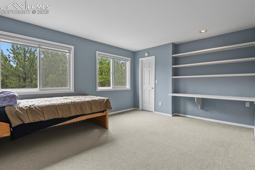 Image 26 of 50: Bedroom with carpet floors and recessed lighting
