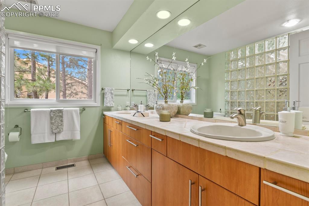 Image 30 of 50: Full bath featuring double vanity, tile patterned floors, and recessed ligh