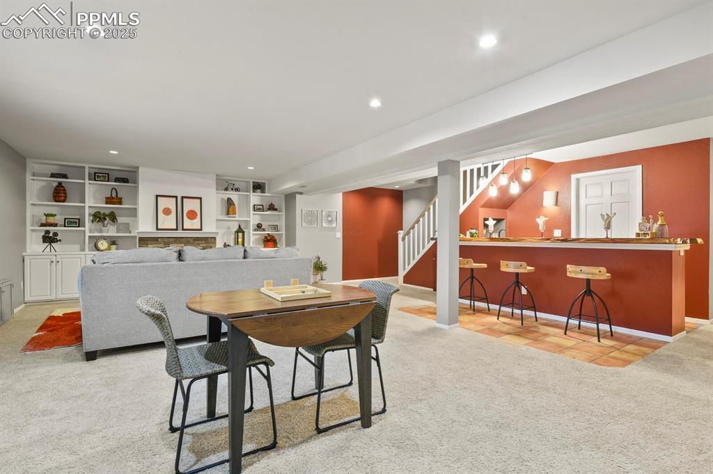 Image 32 of 50: Dining room featuring carpet, stairs, bar with sink, recessed lighting, and