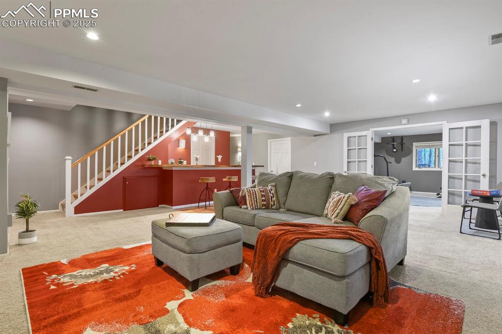Image 33 of 50: Living room with carpet floors, recessed lighting, and stairs
