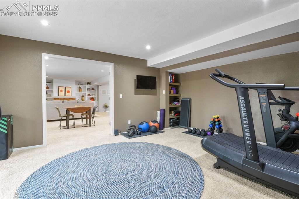 Image 37 of 50: Exercise room with carpet flooring and recessed lighting