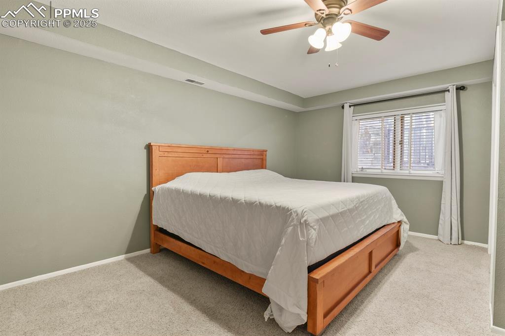 Image 38 of 50: Carpeted bedroom with baseboards and ceiling fan