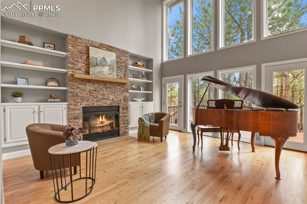 Image 4 of 50: Living area with a high ceiling, built in shelves, light wood-style floors,