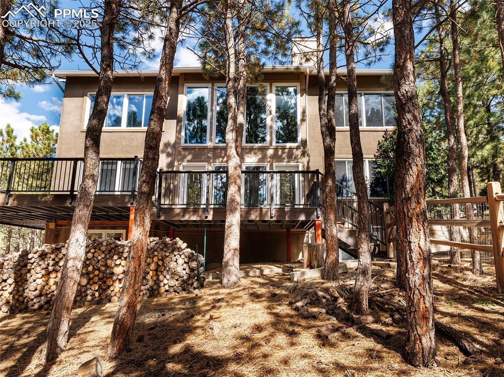 Image 42 of 50: Back of house with a wooden deck and stucco siding