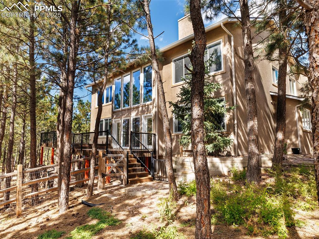 Image 47 of 50: Back of house featuring stucco siding and stairway